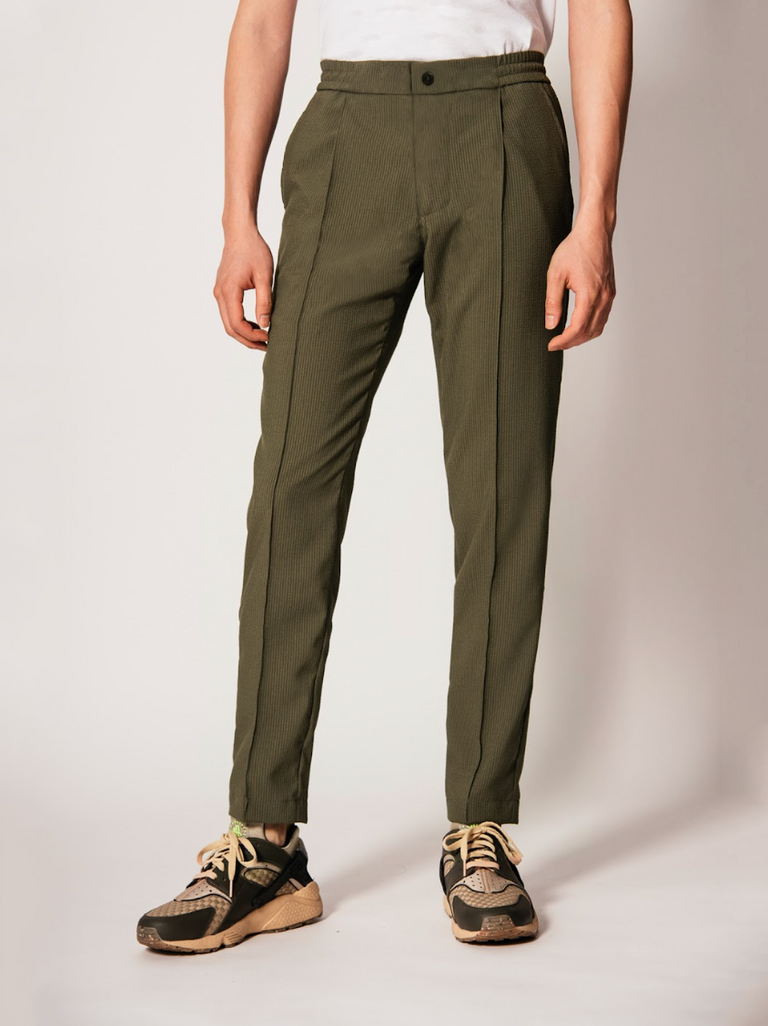 The Vanta Pant by SENECA in Olive Seersucker. Comfortable and versatile men's trousers with elastic waistband, 4 pockets, and a button zipper fly. Replace your chinos, jeans, and khakis perfect for back to the office. caption: Justin is 6'1
